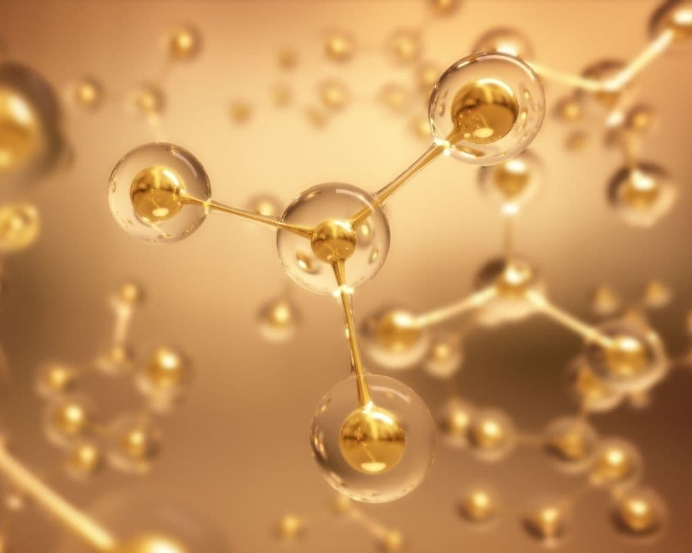 Abstract close-up of golden molecules and bonded spheres on a warm background, representing regenerative cellular science.